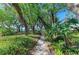 Scenic winding shell path surrounded by lush tropical landscaping and mature trees at 7921 4Th W Ave, Bradenton, FL 34209