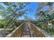 Charming wooden walkway leading to waterfront view, surrounded by tropical foliage at 7921 4Th W Ave, Bradenton, FL 34209