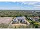 Stunning aerial view of estate home, mature trees, and circular driveway at 8487 Lindrick Ln, Bradenton, FL 34202