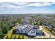 Stunning aerial view of home with screened pool, beautiful landscaping and a paver driveway in a lush neighborhood at 8487 Lindrick Ln, Bradenton, FL 34202