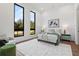 Bright bedroom featuring large windows, neutral decor, and a cozy seating area with an ottoman at 8487 Lindrick Ln, Bradenton, FL 34202