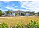 Spacious single-story home with modern architectural details, lush green lawn, and mature palm trees at 8487 Lindrick Ln, Bradenton, FL 34202