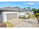 Exterior view showing home with three car garage and paved driveway at 8487 Lindrick Ln, Bradenton, FL 34202