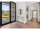 Bright foyer with wood floors, modern console table, and elegant black framed glass door at 8487 Lindrick Ln, Bradenton, FL 34202