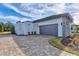 Modern home featuring a two-car garage and a stylish paved driveway at 8487 Lindrick Ln, Bradenton, FL 34202