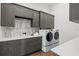 Well-organized laundry room with gray cabinets, quartz countertop, stylish backsplash, and washer/dryer at 8487 Lindrick Ln, Bradenton, FL 34202