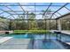 Stunning screened-in pool area with turf and pristine water features at 8487 Lindrick Ln, Bradenton, FL 34202