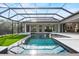 Luxury screened-in pool with turf and pristine water features alongside an outdoor living space at 8487 Lindrick Ln, Bradenton, FL 34202