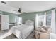 Inviting bedroom featuring a plush chair, bright windows, and a view to the en suite bathroom at 8536 Countess Avenue Cir, Palmetto, FL 34221