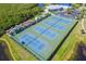 Aerial view of community tennis courts and kayak storage, nestled amidst lush greenery at 866 Audubon Dr, Bradenton, FL 34209