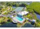 Aerial view showcasing a community pool, tennis courts, clubhouse, and lush green landscape in a serene setting at 866 Audubon Dr, Bradenton, FL 34209