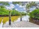 Wooden dock featuring sturdy pillars, providing access to tranquil waters surrounded by lush greenery at 866 Audubon Dr, Bradenton, FL 34209