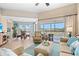 Bright living room features a comfortable seating arrangement and sliding glass doors to the balcony with water views at 866 Audubon Dr, Bradenton, FL 34209