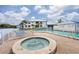 Community spa and pool with lounge chairs, landscaping and a building under a partly cloudy sky at 866 Audubon Dr, Bradenton, FL 34209