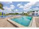 Community pool and spa with lounge chairs and tropical landscaping under a partly cloudy sky at 866 Audubon Dr, Bradenton, FL 34209