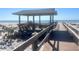 Charming gazebo on a sandy beach with clear ocean views, accessible by a wooden boardwalk at 9400 Little Gasparilla Is # F6, Placida, FL 33946