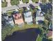 Aerial view showing the layout of the home, its backyard pool, and its proximity to a scenic lake at 9590 Knightsbridge Cir, Sarasota, FL 34238