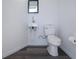 Modern powder room featuring wall-mounted sink, mirror, white toilet, and gray flooring at 9590 Knightsbridge Cir, Sarasota, FL 34238