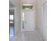 Home's entryway featuring tiled flooring, a view of the living room, and a white front door at 9590 Knightsbridge Cir, Sarasota, FL 34238