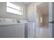 Bright laundry room with washer and dryer with view to other room at 9590 Knightsbridge Cir, Sarasota, FL 34238