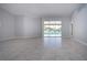 Spacious living room featuring neutral paint and ceramic flooring leading out to the screened lanai at 9590 Knightsbridge Cir, Sarasota, FL 34238