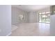 Spacious living room featuring neutral paint and ceramic flooring leading out to the screened lanai at 9590 Knightsbridge Cir, Sarasota, FL 34238