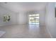 Spacious living room featuring neutral paint and ceramic flooring leading out to the screened lanai at 9590 Knightsbridge Cir, Sarasota, FL 34238