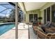 Outdoor patio with screened-in pool, lounge seating, and sliding glass doors to bedroom at 9590 Knightsbridge Cir, Sarasota, FL 34238