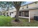 Backyard view highlighting screened patio, large shade tree, and well-maintained lawn at 1038 Grantham Dr, Sarasota, FL 34234