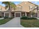 Charming townhome featuring a well-manicured lawn, brown shutters, and a private one car garage at 1038 Grantham Dr, Sarasota, FL 34234