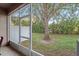 Screened patio offers a peaceful outdoor space overlooking the lawn and mature tree at 1038 Grantham Dr, Sarasota, FL 34234