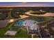 Aerial view of the community clubhouse, pool, and surrounding neighborhood at sunset at 14906 Lyla Ter, Bradenton, FL 34211