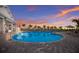 Beautiful community pool featuring ample seating, palm trees, and adjacent clubhouse at sunset at 14906 Lyla Ter, Bradenton, FL 34211