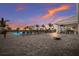 Resort-style pool area with lounge chairs, palm trees, and an open-air pavilion with game area at sunset at 14906 Lyla Ter, Bradenton, FL 34211