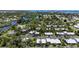 Expansive aerial view of a residential community surrounded by lush greenery and tranquil waterways at 155 Jose Gaspar Dr # 155, Englewood, FL 34223