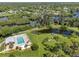 Stunning aerial view of a community pool, pond, and lush landscaping, capturing the peaceful atmosphere at 155 Jose Gaspar Dr # 155, Englewood, FL 34223