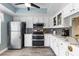 Bright kitchen featuring stainless steel appliances, white cabinetry, and a stylish tile backsplash at 155 Jose Gaspar Dr # 155, Englewood, FL 34223