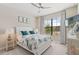 Cozy bedroom with white furniture, a ceiling fan, a large window, and tasteful decor at 15607 White Linen Dr, Lakewood Ranch, FL 34211