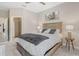 Bedroom with a wooden bed frame, grey and white bedding, and matching nightstands with lamps at 15607 White Linen Dr, Lakewood Ranch, FL 34211