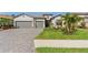 Beautiful home exterior with a well-manicured lawn, palm trees, and a three-car garage at 15607 White Linen Dr, Lakewood Ranch, FL 34211