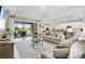 Open-concept living room with modern furnishings, sliding glass doors, and views of the outdoor living area at 15607 White Linen Dr, Lakewood Ranch, FL 34211