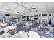 Outdoor dining area with white tables and chairs in a modern patio setting at 15607 White Linen Dr, Lakewood Ranch, FL 34211