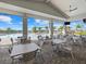 Outdoor dining area overlooking a luxurious pool with sunny skies and palm trees at 15607 White Linen Dr, Lakewood Ranch, FL 34211