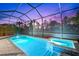 Inviting pool and spa with ambient lighting, nestled within a screened enclosure for ultimate privacy and relaxation at 17522 Northwood Pl, Bradenton, FL 34202