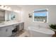 Bright bathroom features a soaking tub, double vanity, and natural light from the window at 1901 Everson St, Bradenton, FL 34208