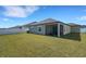 Rear view of the home highlighting the screened lanai and the grassy backyard at 1901 Everson St, Bradenton, FL 34208