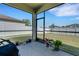 Enclosed back patio offers a cozy outdoor seating area with views of the fenced backyard and lush green grass at 1901 Everson St, Bradenton, FL 34208
