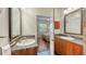 Bathroom with double granite countertop vanities leading into bedroom through open doorway at 2047 Roselawn St, Sarasota, FL 34231