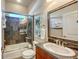 Bathroom with tile surround tub and shower, granite countertop and framed mirror at 2047 Roselawn St, Sarasota, FL 34231