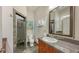 Well-lit bathroom with stone-accented shower, granite countertop with a vessel sink and decorative mirror at 2047 Roselawn St, Sarasota, FL 34231